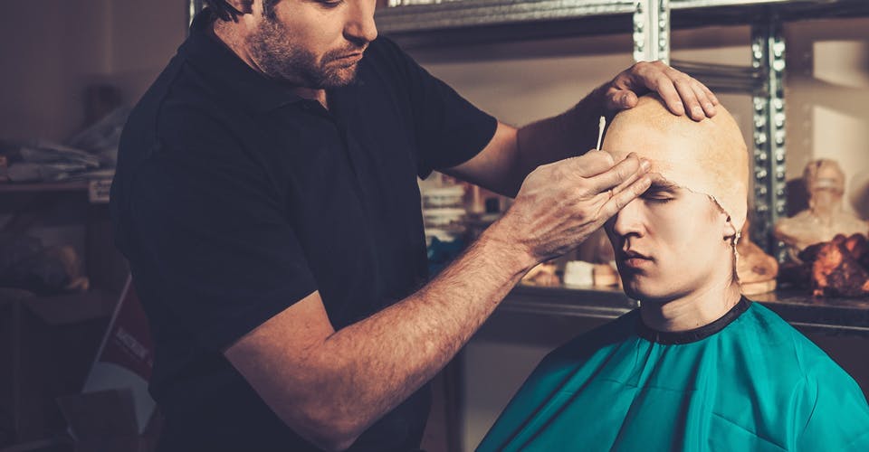 makeup artist applying special fx makeup on a client