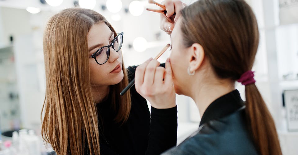 makeup artist applying makeup on a client